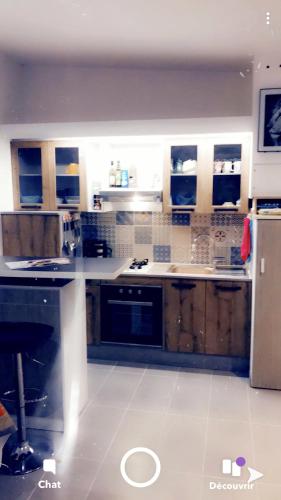 une cuisine avec des armoires en bois et un réfrigérateur dans l'établissement Eyssam d’or, à Dijon