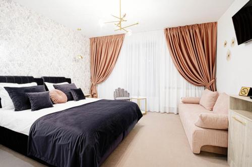 a bedroom with a large bed and a couch at LIANE BOUTIQUE HOTEL in Câmpulung Moldovenesc