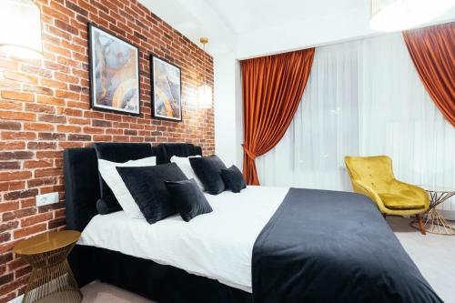 a bedroom with a bed and a brick wall at LIANE BOUTIQUE HOTEL in Câmpulung Moldovenesc