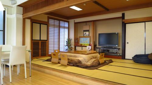 ein Wohnzimmer mit einem großen Bett und einem TV in der Unterkunft K's House MtFuji -ケイズハウスMt富士- Travelers Hostel- Lake Kawaguchiko in Fujikawaguchiko