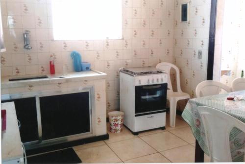 een kleine keuken met een fornuis en een wastafel bij Apartamento Iguaba Grande, bairro Canellas City , em frente ao trailer do popeye in Iguaba Grande