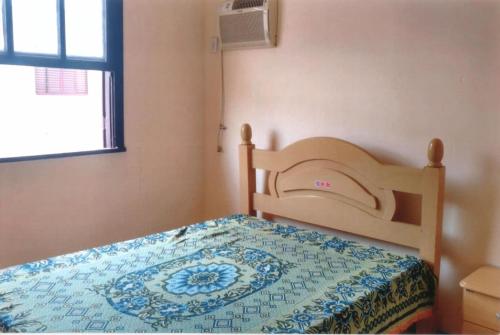 ein Schlafzimmer mit einem Bett mit einer Decke darauf in der Unterkunft Apartamento Iguaba Grande, bairro Canellas City , em frente ao trailer do popeye in Iguaba Grande