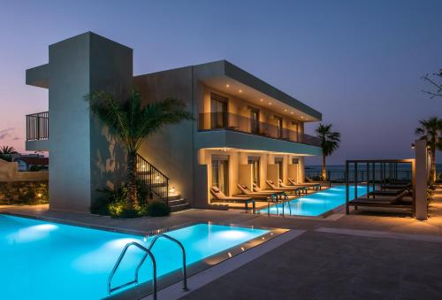 a house with a swimming pool at night at Riviera Boutique Hotel in Stalida