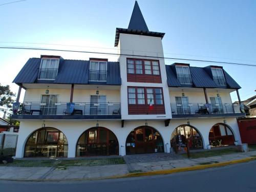 a large white building with a black roof at Posada Mia Nonna in Villa General Belgrano