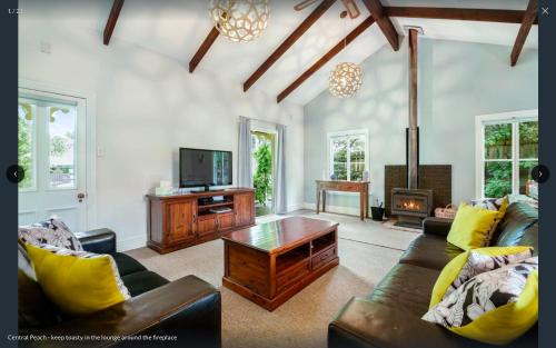 a living room with a couch and a tv at Central Peach - Queenstown Holiday Home in Queenstown