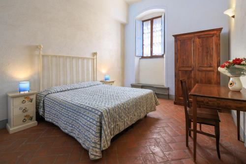 a bedroom with a bed and a table and a desk at Antico Pastificio in Greve in Chianti