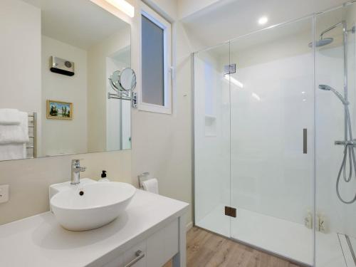 a white bathroom with a sink and a shower at Stonehill Villa - 5 Bed in Queenstown