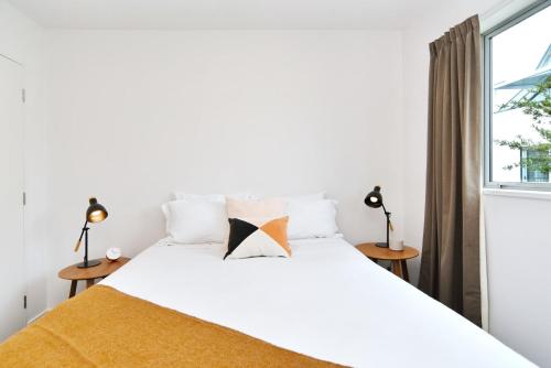 a bedroom with a white bed with a window at Armagh Apartment 3 - Christchurch Holiday Homes in Christchurch