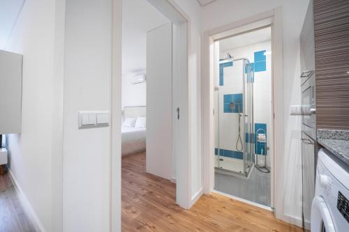 a bathroom with a glass shower in a white room at Bracara Guest House "São Bento" - "Palácio do Raio" in Braga