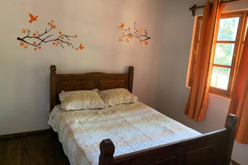 1 dormitorio con 1 cama con pájaros en la pared en Cabaña Campestre Miramar en Playa Verde