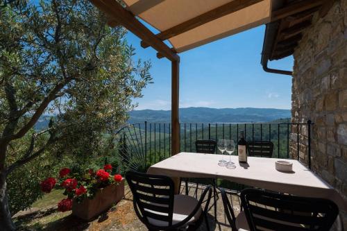 a table with wine glasses and flowers on a balcony at Castello Di Montegonzi in Greve in Chianti