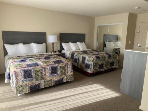 a hotel room with two beds and a mirror at Apple Valley Hotel & Lodge in Apple Valley