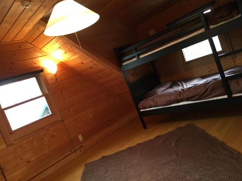 an attic room with a bunk bed and a window at トラストメゾン白田 in Higashiizu