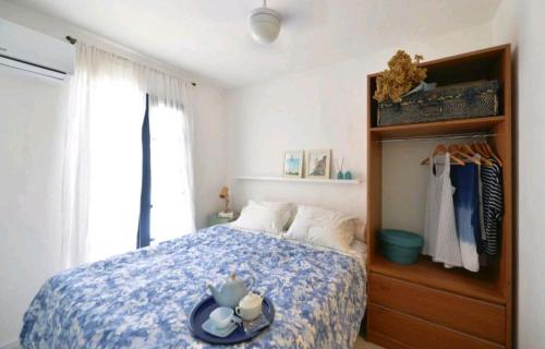 a bedroom with a bed with a blue comforter at Casa Boutique Peró in Cabo Frio