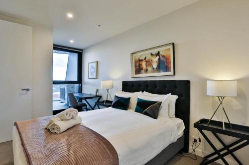 um quarto com uma cama grande e uma toalha em Next to 'The Glen Shopping Centre' Apartment em Glen Waverley