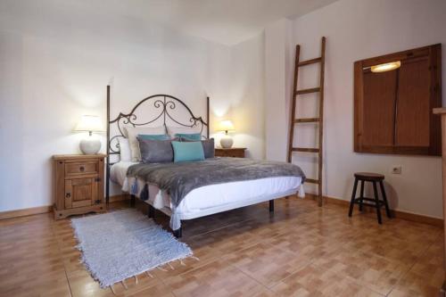 a bedroom with a bed with blue pillows and a ladder at Horizonte - Apts IAN Jandía Sur in La Lajita