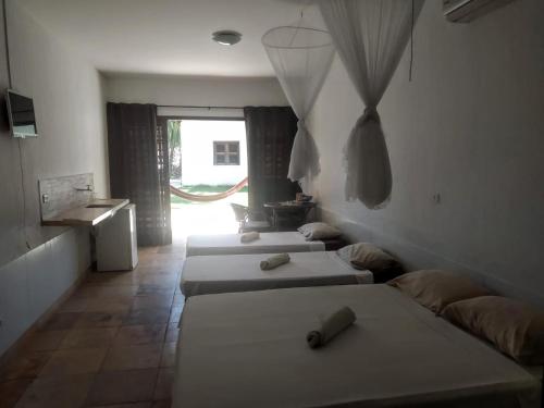 três camas num quarto com uma janela em Casa Martina em Cumbuco