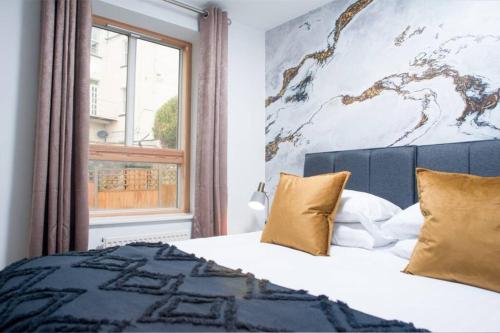 una camera da letto con un letto con una grande finestra di Clifton Jewel - 4 bed townhouse with parking. MyCityHaven a Bristol