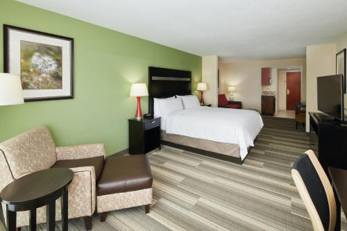 a hotel room with a bed and a chair at Holiday Inn Express & Suites I-26 & Us 29 At Westgate Mall by IHG in Spartanburg