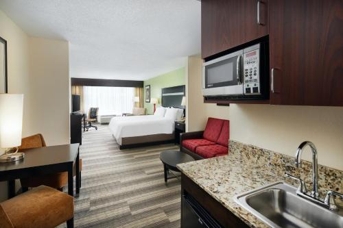 a hotel room with a kitchen and a bedroom at Holiday Inn Express & Suites I-26 & Us 29 At Westgate Mall by IHG in Spartanburg