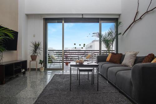 a living room with a couch and a table at Infinito by Zamá Homes in Playa del Carmen