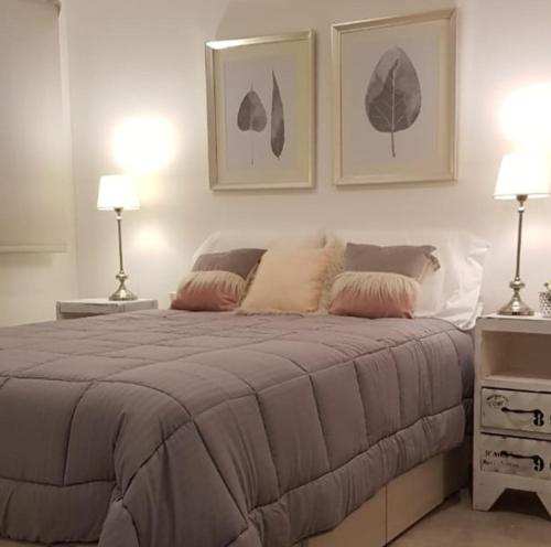 a bedroom with a large bed with two lamps at Aliaga Mar del Plata in Mar del Plata