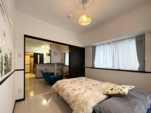 um quarto com uma cama e uma grande janela em EX Itoman Apartment 401 em Itoman