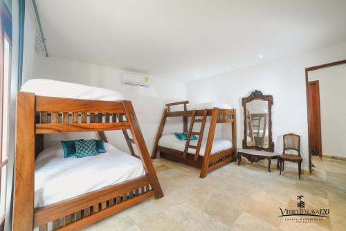 a room with two bunk beds and a mirror at Casa Virrey Eslava 120 inside the Walled City of Cartagena in Cartagena de Indias