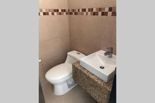 a bathroom with a toilet and a sink at Very comfortable family apartment on Salinas Beach Super fast internet in Salinas
