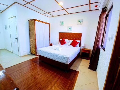 パングラオにあるSunville Hotel and Restaurantのベッドルーム1室(赤い枕のベッド1台付)