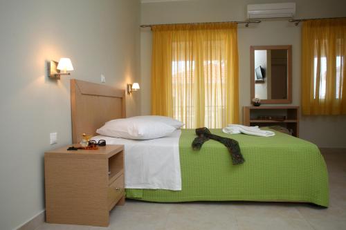 1 dormitorio con 1 cama con manta verde y vestidor en Pantazis Studios, en Nikiana