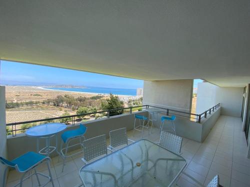 a balcony with chairs and tables and a view of the ocean at Apartamento Puerto Velero Tongoy in Puerto Velero