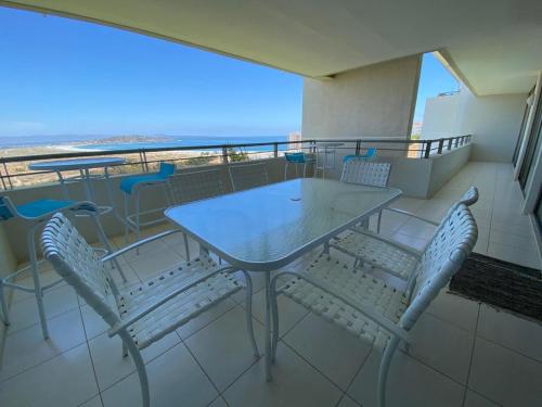 a table and chairs on a balcony with a view of the ocean at Apartamento Puerto Velero Tongoy in Puerto Velero