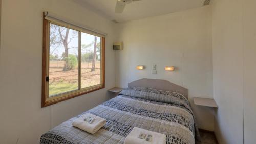 A bed or beds in a room at Cobar Caravan Park