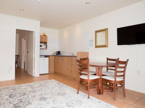 a kitchen and dining room with a table and chairs at Commodores Lodge in Russell