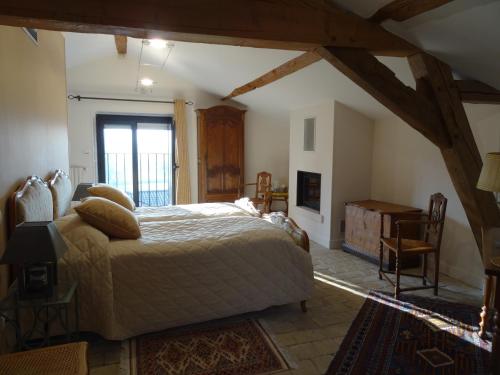 a bedroom with a large bed and a fireplace at Gentilhommière de Collonges in Prissé