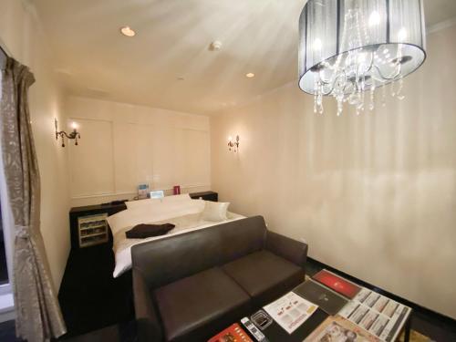 a room with a bed and a couch and a chandelier at リバーサイド in Imabari