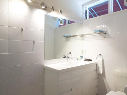 a white bathroom with a sink and a toilet at Commodores Lodge in Russell