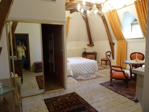 a bedroom with a bed and a table and a mirror at Gentilhommière de Collonges in Prissé