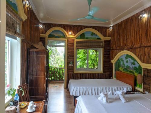 - une chambre avec 2 lits, des murs en bois et des fenêtres dans l'établissement Ninh Binh Greenland Homestay, à Ninh Binh