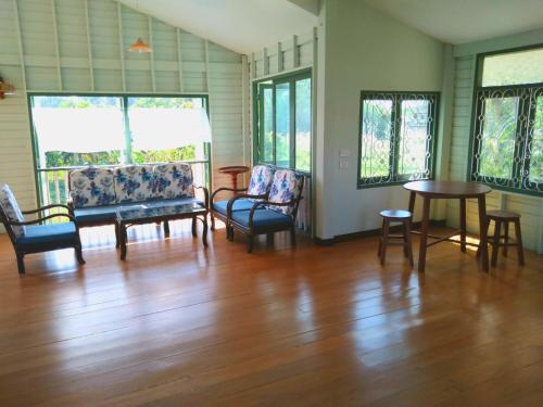 a living room with chairs and a wooden floor at Green Home by Canal in Ban Tha Long Hip