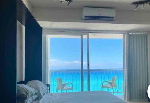 a bedroom with a bed and a view of the ocean at Studio oceanfront prime location in Cancún