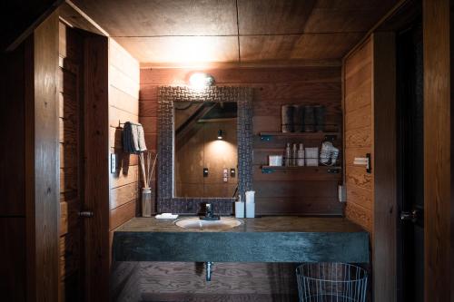 a bathroom with a sink and a mirror at LOGIN OKINAWA -soil- in Onna