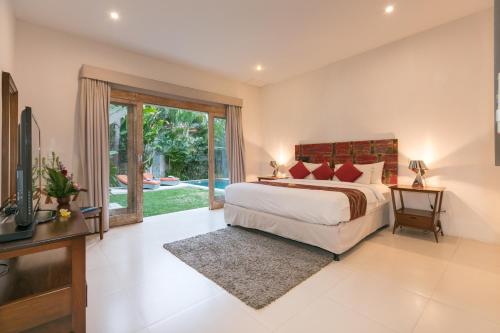 a bedroom with a large bed and a television at Villa Briana Seminyak by Bali Villas R Us in Seminyak