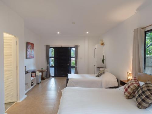 two beds in a room with white walls at Granada Beach Resort - Adults Only in Boljoon