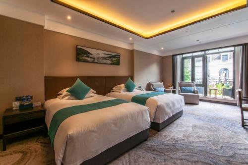 a hotel room with two beds and a large window at SSAW Boutique Hotel Lishui Jiarui in Lishui