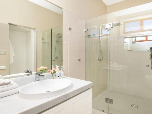 a bathroom with a sink and a glass shower at Advilla in Bowral