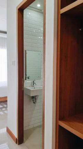 ein Badezimmer mit Waschbecken und Spiegel in der Unterkunft RakaAyu Kuta in Kuta