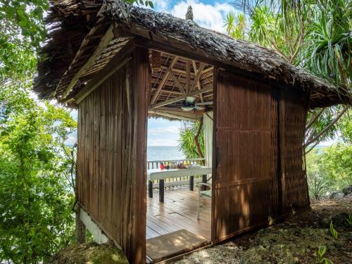 a wooden hut with a deck with a view of the ocean at Granada Beach Resort - Adults Only in Boljoon
