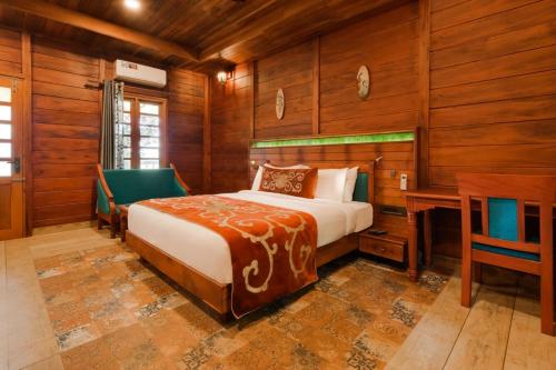 una camera da letto con un letto, una scrivania e delle sedie di Southern Panorama Indriya Resorts & Spa a Munnar
